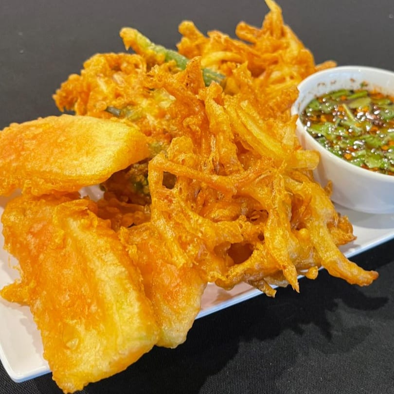 Crispy golden-fried Asian-fusion tempura vegetables and tofu served with a dipping sauce.